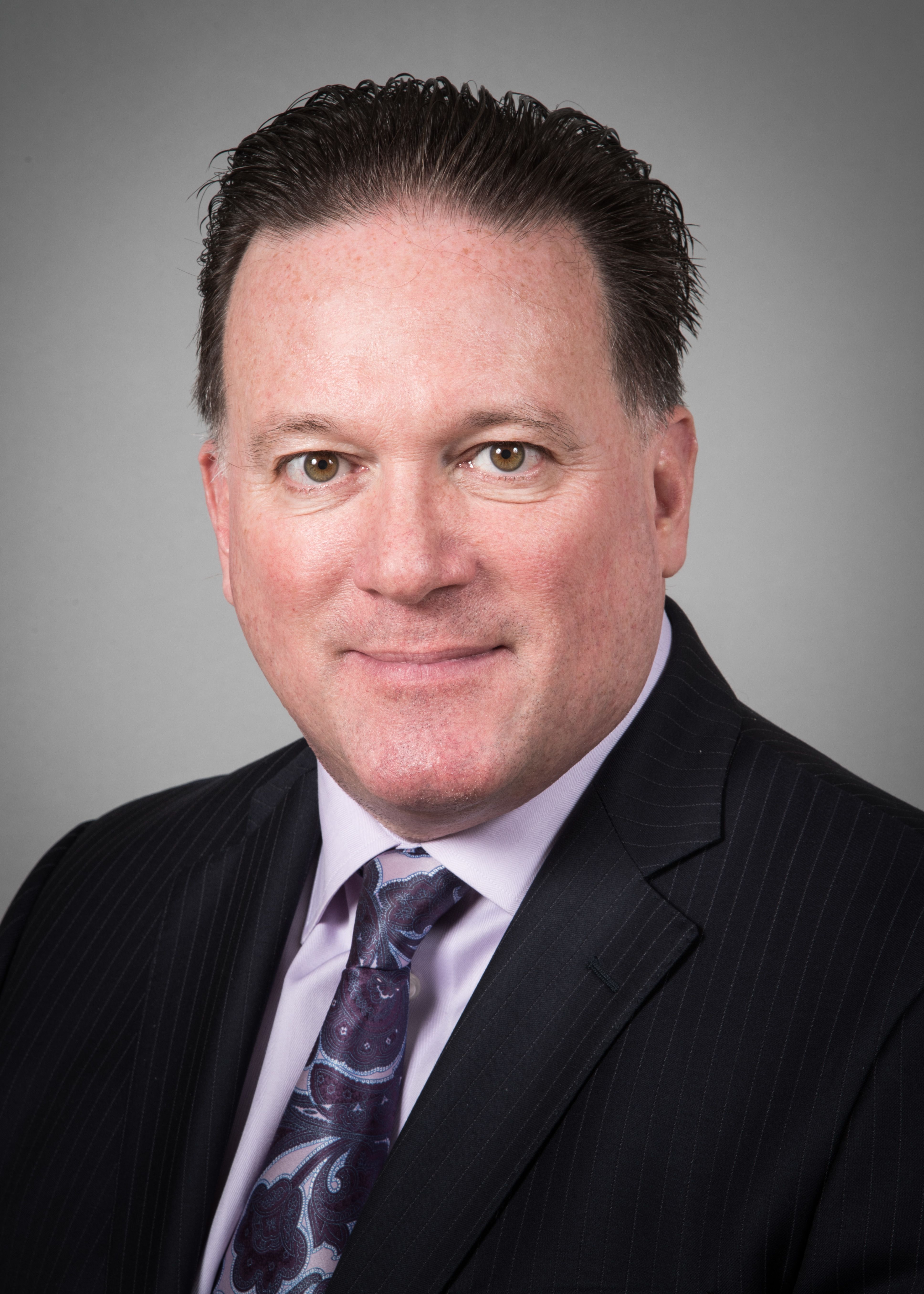 Randolph DiLorenzo, MD, wearing a dark suit and purple tie